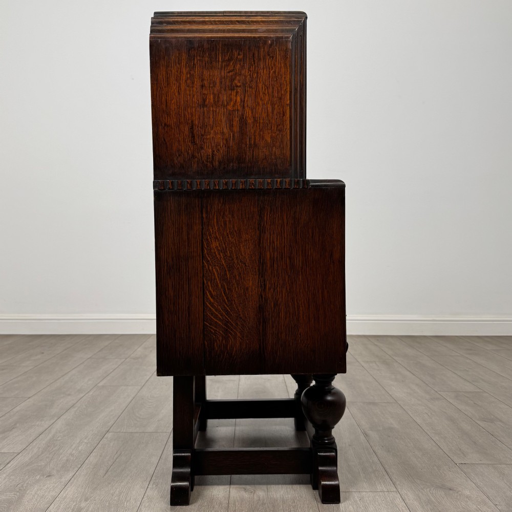 An early 20th-century dark oak writing bureau featuring a sloped fall-front lid above two drawers, supported on turned bulbous legs with stretchers. View VIII