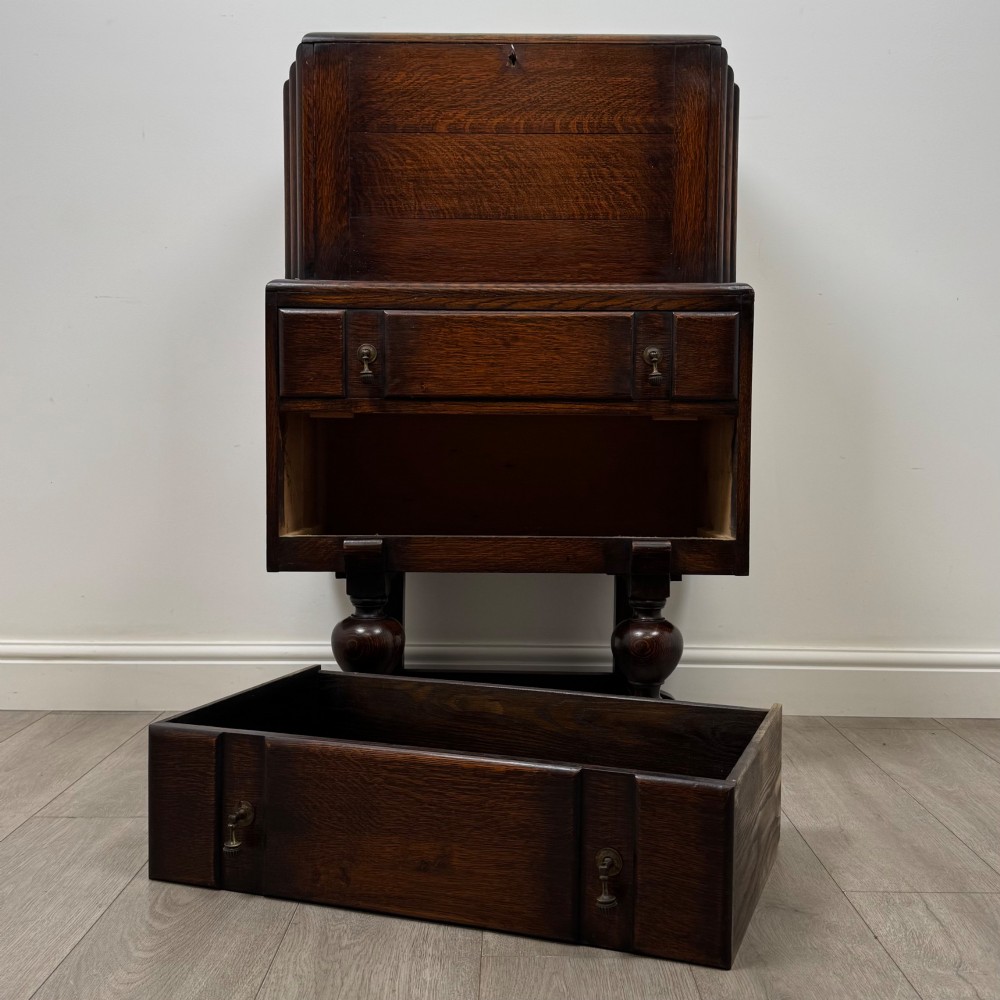 An early 20th-century dark oak writing bureau featuring a sloped fall-front lid above two drawers, supported on turned bulbous legs with stretchers. View XII