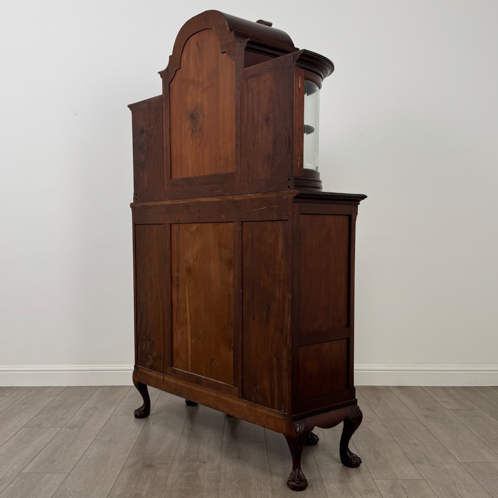 A 19th-century Queen Anne style dark walnut display cabinet featuring curved glass side sections, an arched central glazed door with a carved shell crest, and cabriole legs. View VII
