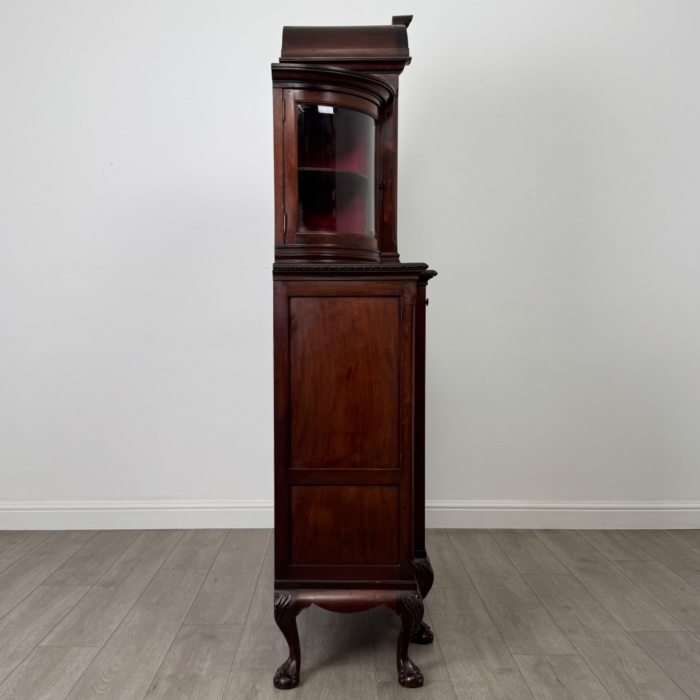 A 19th-century Queen Anne style dark walnut display cabinet featuring curved glass side sections, an arched central glazed door with a carved shell crest, and cabriole legs. View VIII