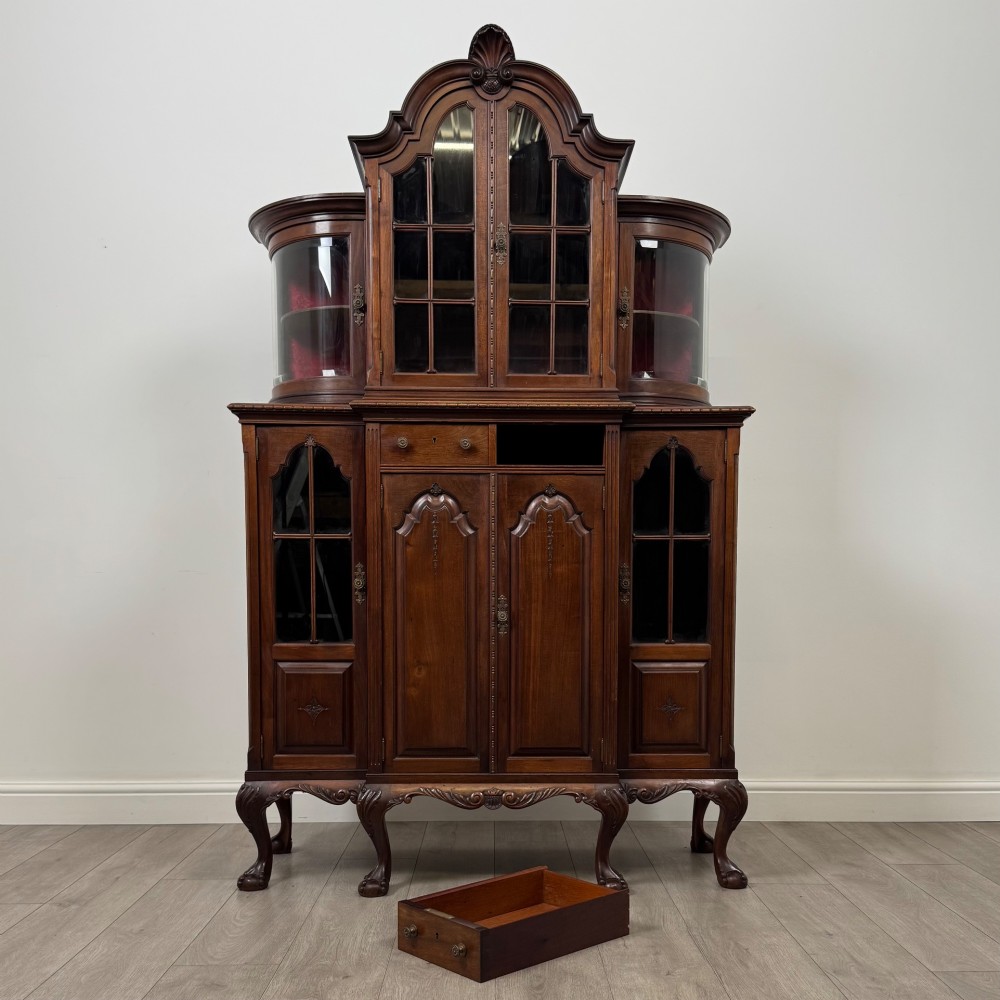 A 19th-century Queen Anne style dark walnut display cabinet featuring curved glass side sections, an arched central glazed door with a carved shell crest, and cabriole legs. View XI