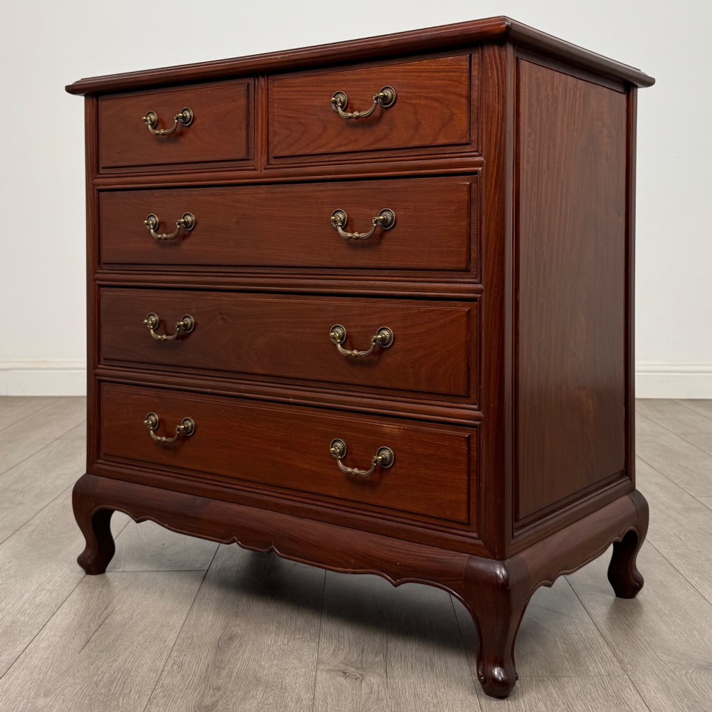 A mahogany chest of drawers featuring a two-over-three drawer arrangement supported on cabriole feet with brass drop handles. View II