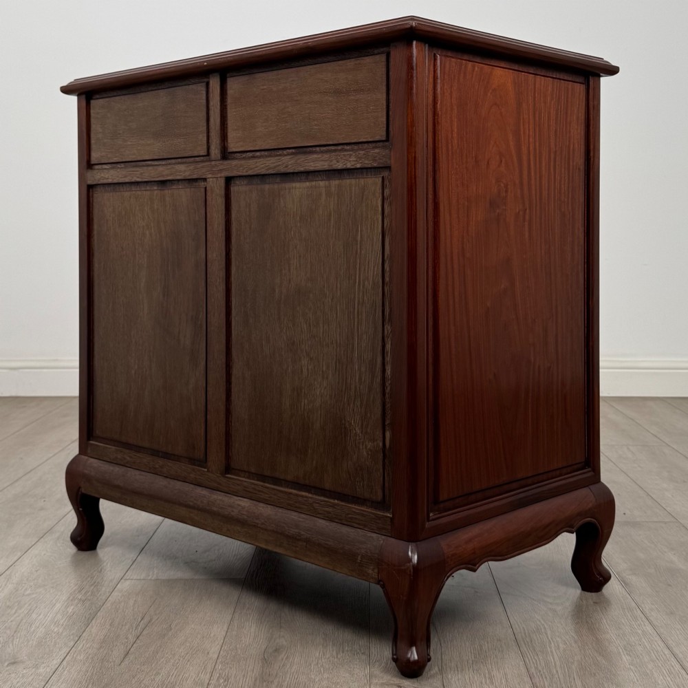 A mahogany chest of drawers featuring a two-over-three drawer arrangement supported on cabriole feet with brass drop handles. View VI