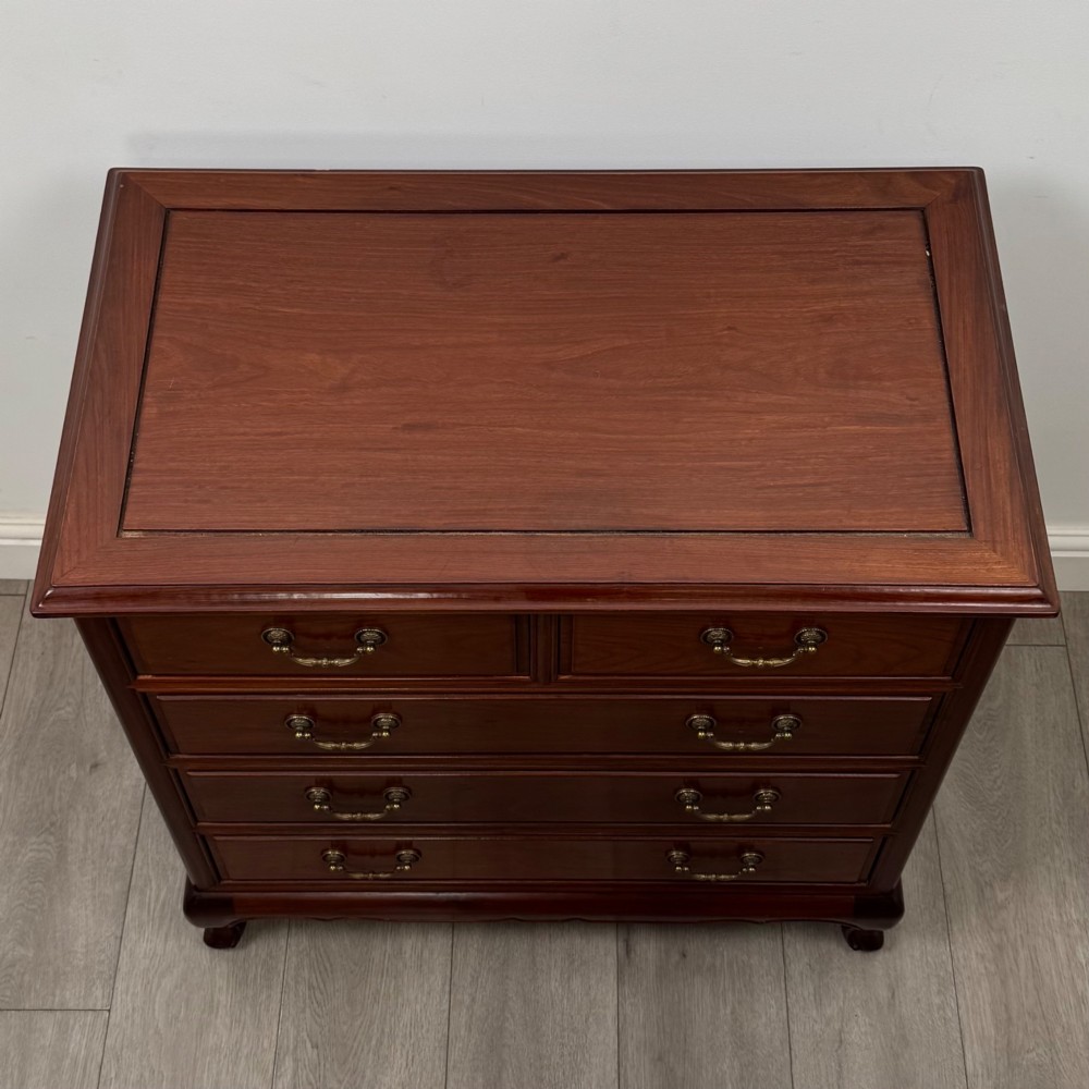 A mahogany chest of drawers featuring a two-over-three drawer arrangement supported on cabriole feet with brass drop handles. View IX