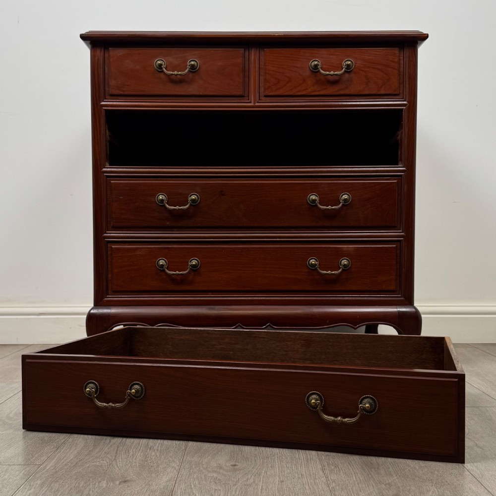 A mahogany chest of drawers featuring a two-over-three drawer arrangement supported on cabriole feet with brass drop handles. View X