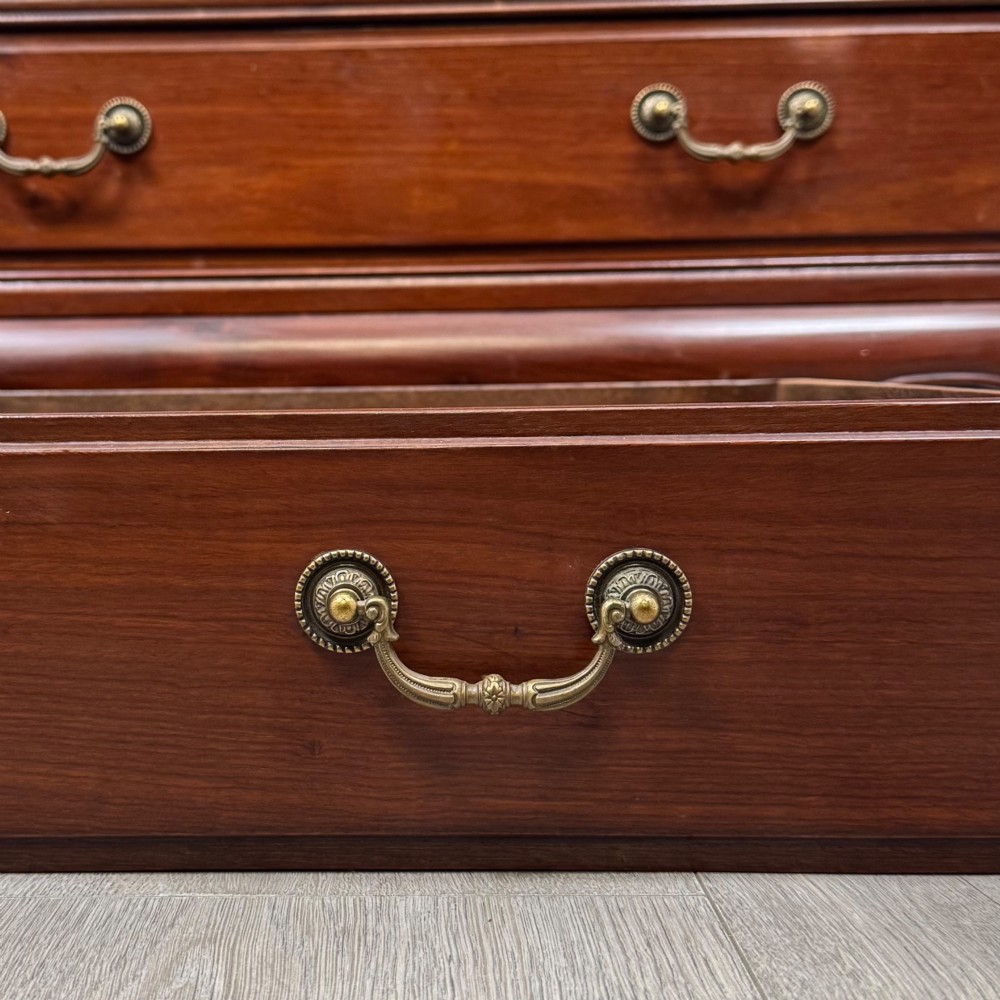 A mahogany chest of drawers featuring a two-over-three drawer arrangement supported on cabriole feet with brass drop handles. View XI
