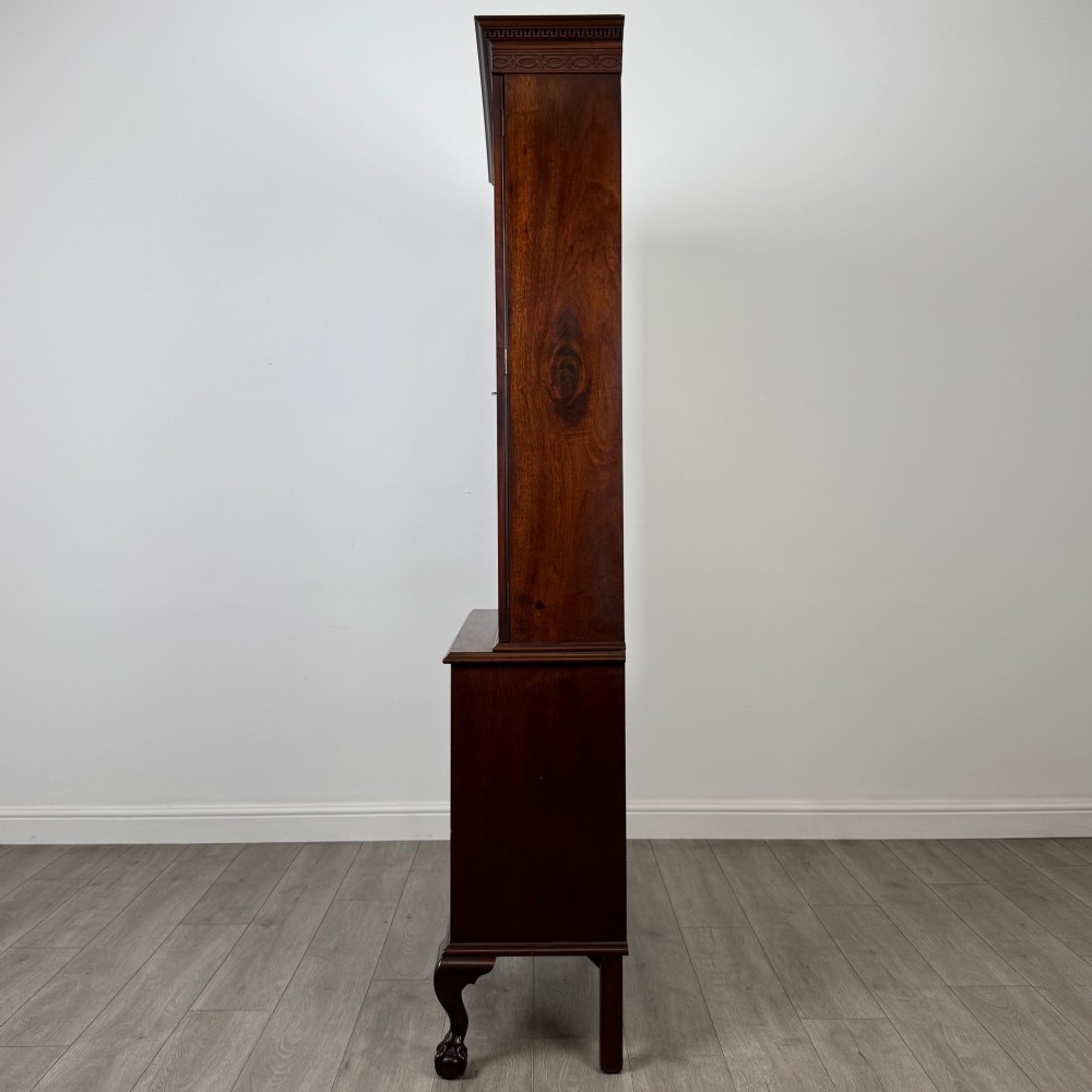 A 20th-century Chippendale style mahogany bookcase featuring two upper glazed doors with diamond pattern astragal glazing and a two-door cupboard base raised on cabriole legs with claw and ball feet. View IV
