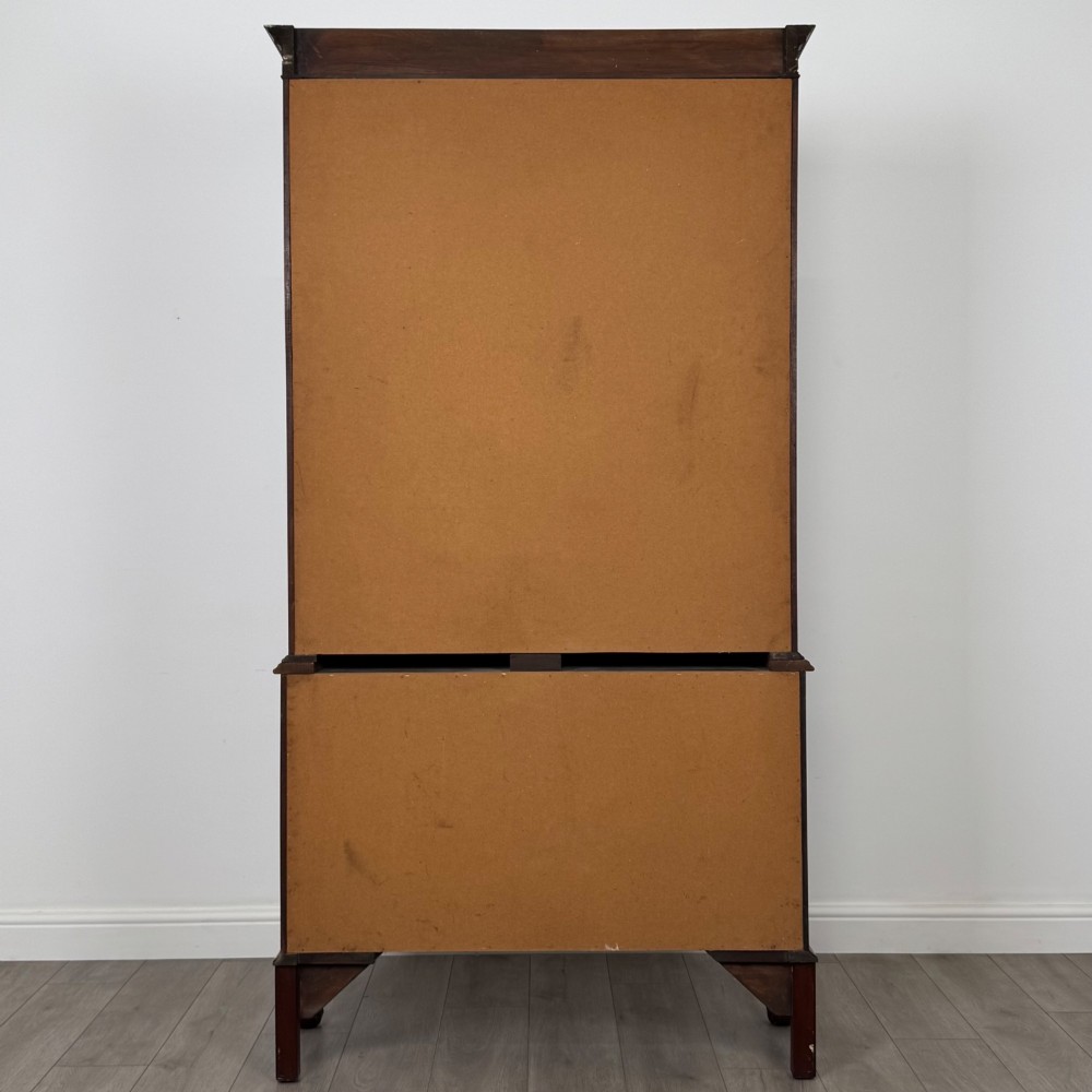 A 20th-century Chippendale style mahogany bookcase featuring two upper glazed doors with diamond pattern astragal glazing and a two-door cupboard base raised on cabriole legs with claw and ball feet. View VI