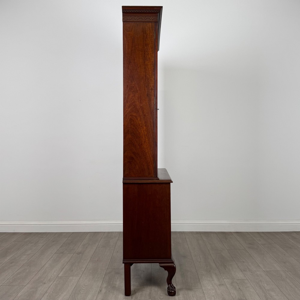 A 20th-century Chippendale style mahogany bookcase featuring two upper glazed doors with diamond pattern astragal glazing and a two-door cupboard base raised on cabriole legs with claw and ball feet. View VIII