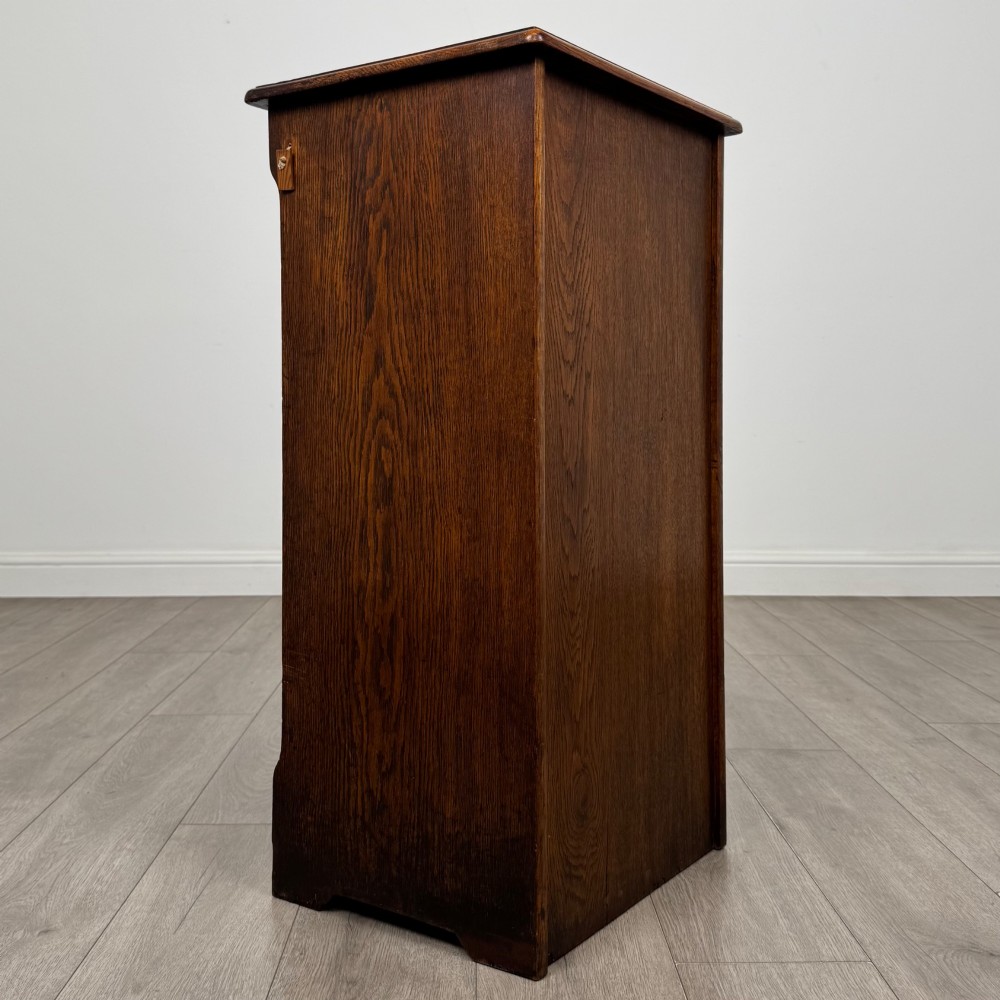 An antique dark oak tambour cabinet featuring a vertical wooden slat roll-front door and top brass locking mechanism. View V