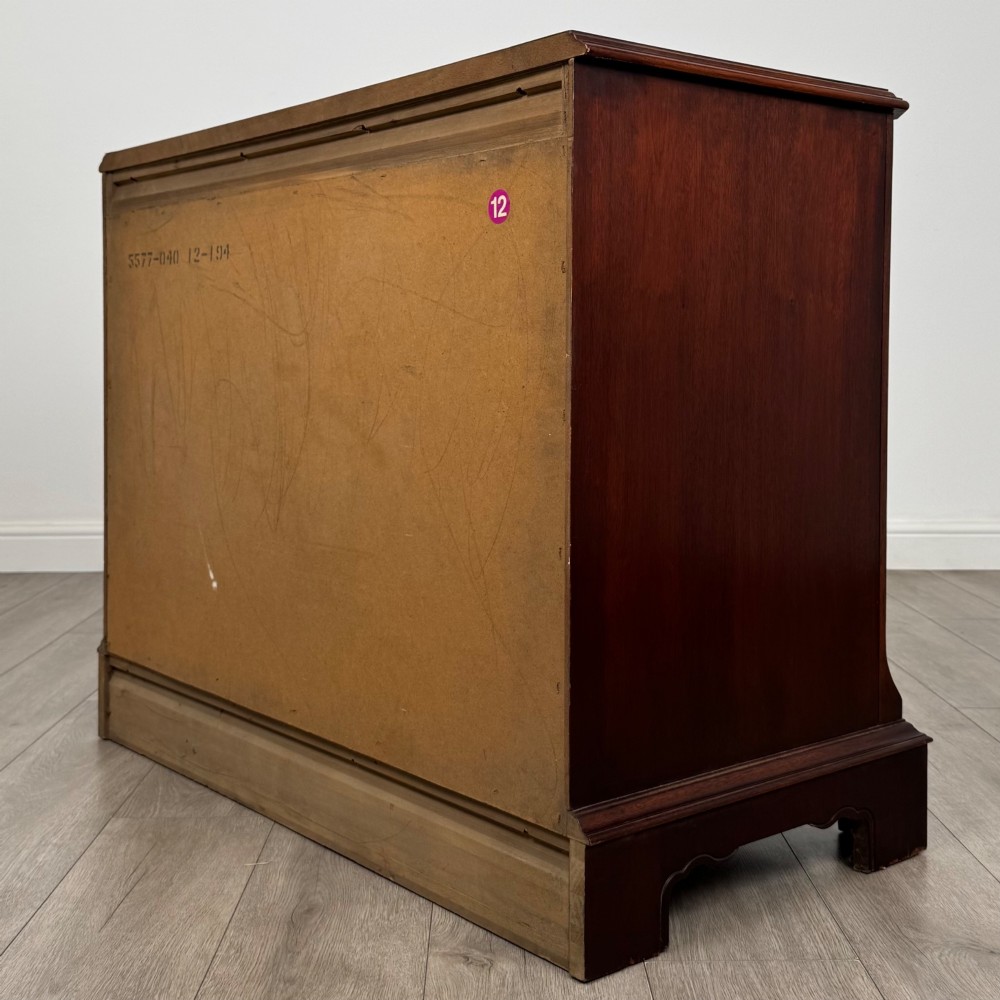 A 20th-century American mahogany chest of drawers featuring two small top drawers, two full-width lower drawers, brass bail handles, fluted quarter-columns, and bracket feet. View VI