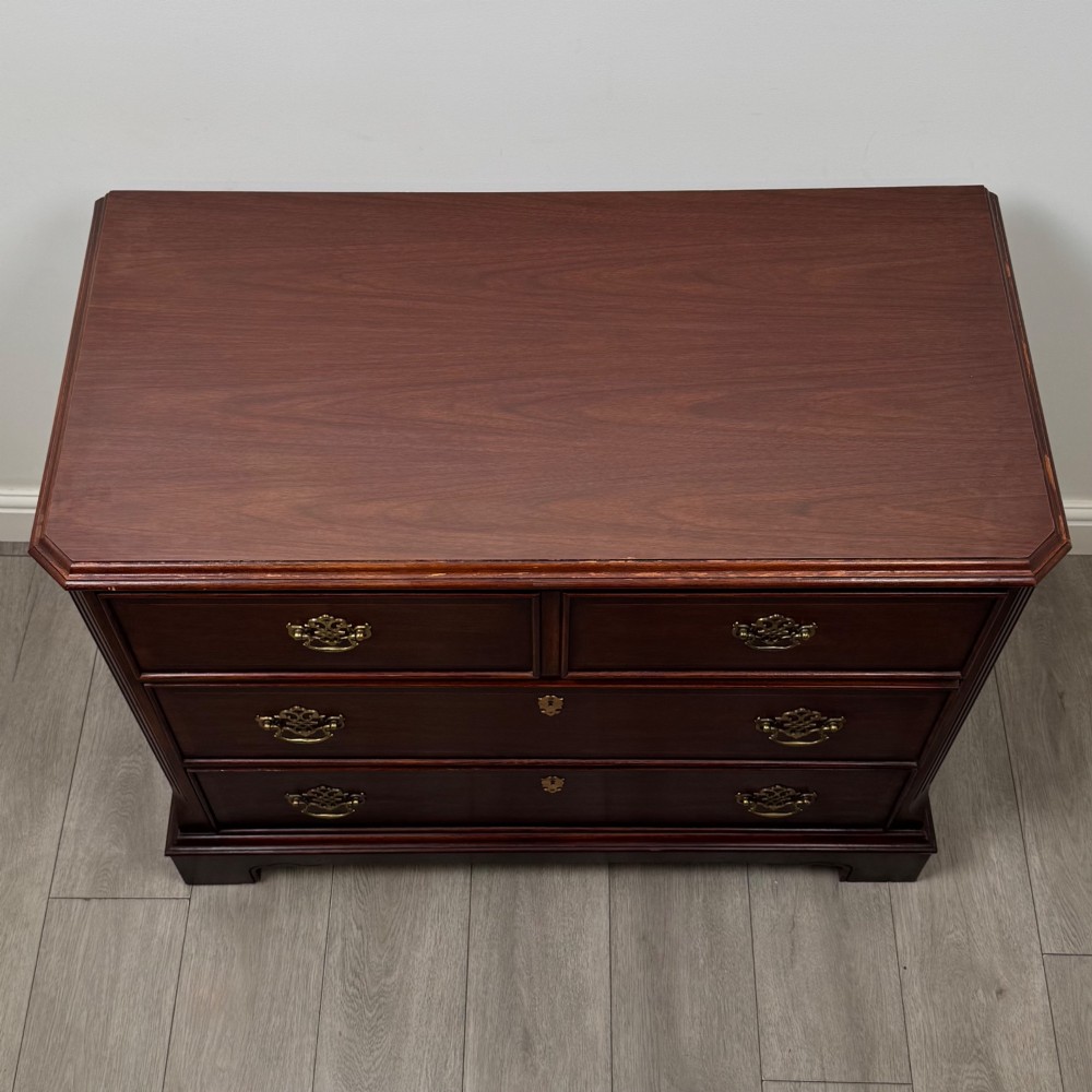 A 20th-century American mahogany chest of drawers featuring two small top drawers, two full-width lower drawers, brass bail handles, fluted quarter-columns, and bracket feet. View IX