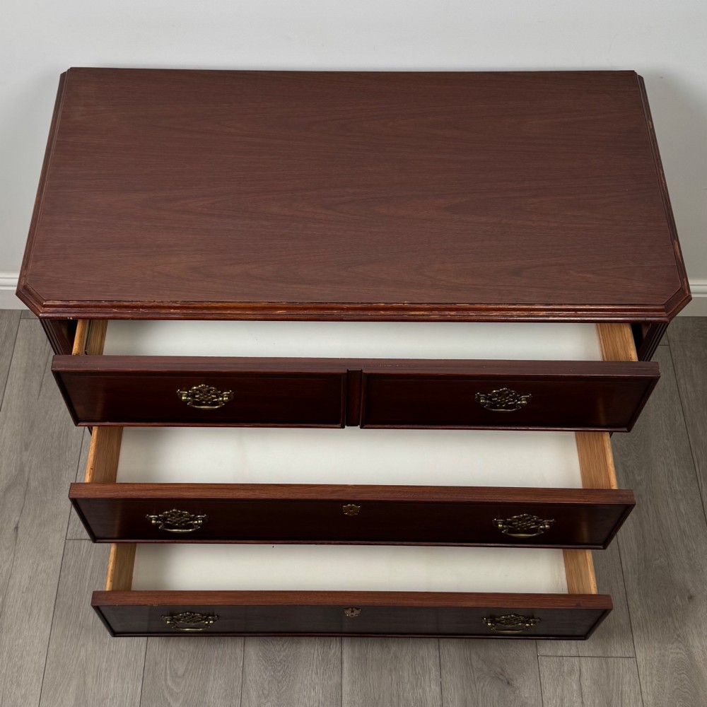 A 20th-century American mahogany chest of drawers featuring two small top drawers, two full-width lower drawers, brass bail handles, fluted quarter-columns, and bracket feet. View XI
