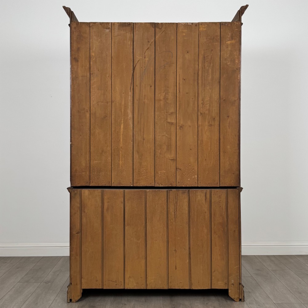 An Edwardian walnut linen press featuring a moulded top cornice, two large upper recessed panel doors, and a lower chest of drawers with brass drop handles. View VI