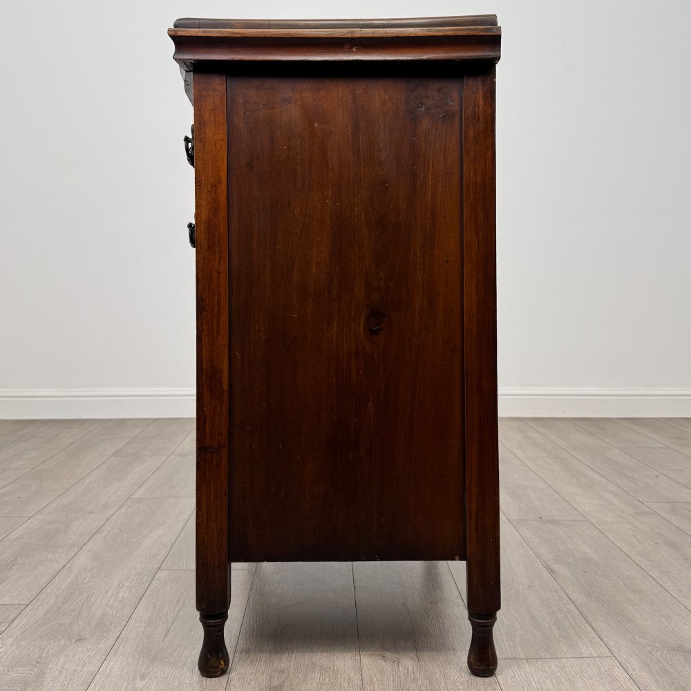 A 19th-century Victorian walnut chest of drawers featuring ornate relief carvings across the drawer fronts and metal drop handles. View III