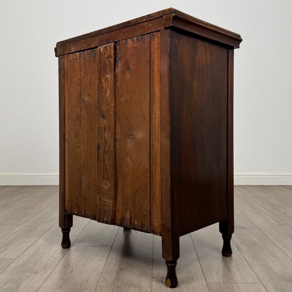 A 19th-century Victorian walnut chest of drawers featuring ornate relief carvings across the drawer fronts and metal drop handles. View VI