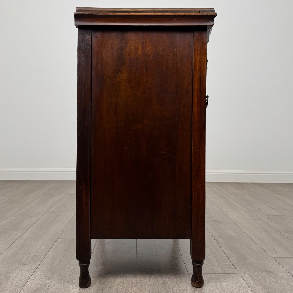 A 19th-century Victorian walnut chest of drawers featuring ornate relief carvings across the drawer fronts and metal drop handles. View VII