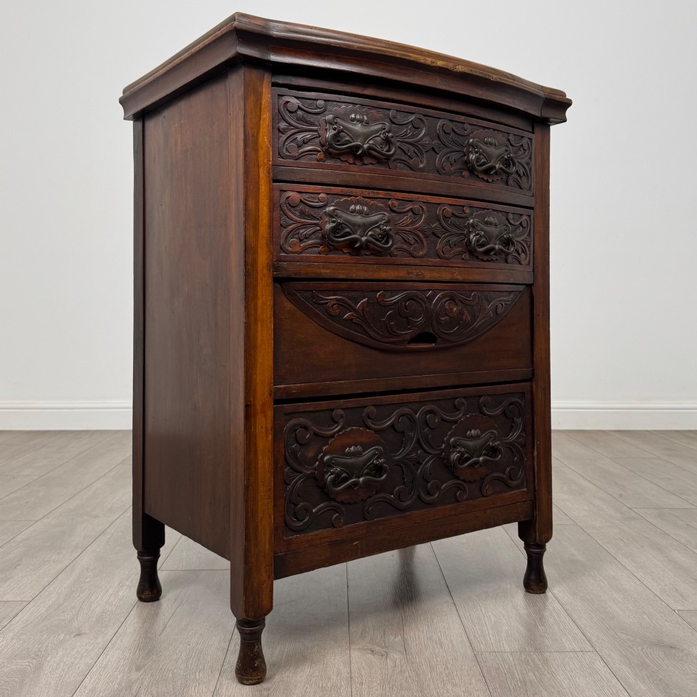 A 19th-century Victorian walnut chest of drawers featuring ornate relief carvings across the drawer fronts and metal drop handles. View VIII