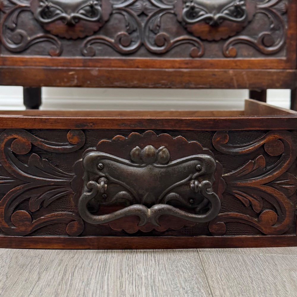 A 19th-century Victorian walnut chest of drawers featuring ornate relief carvings across the drawer fronts and metal drop handles. View XI