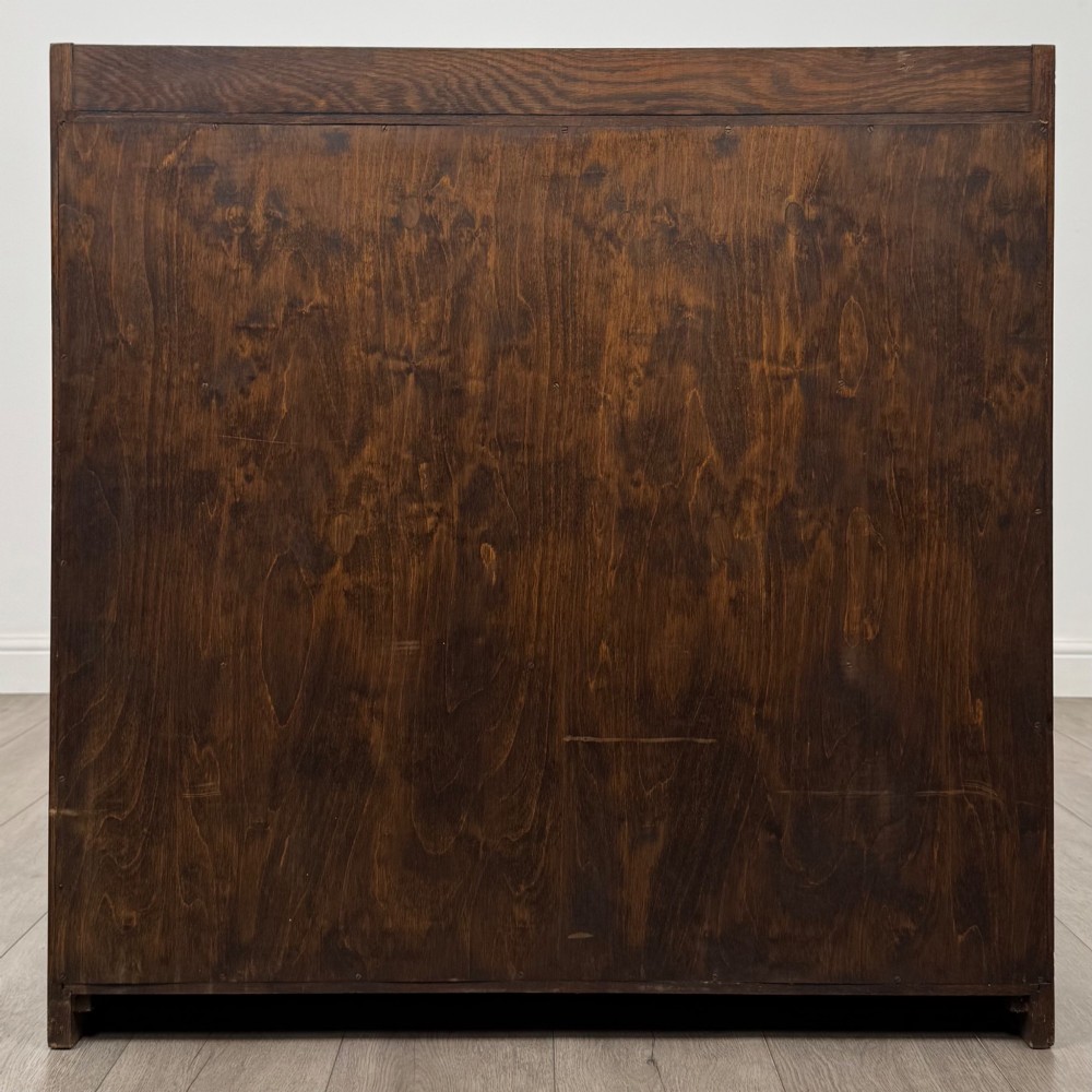 A mid-twentieth-century dark oak display cabinet featuring three interior shelf tiers enclosed by sliding glass doors. View VI