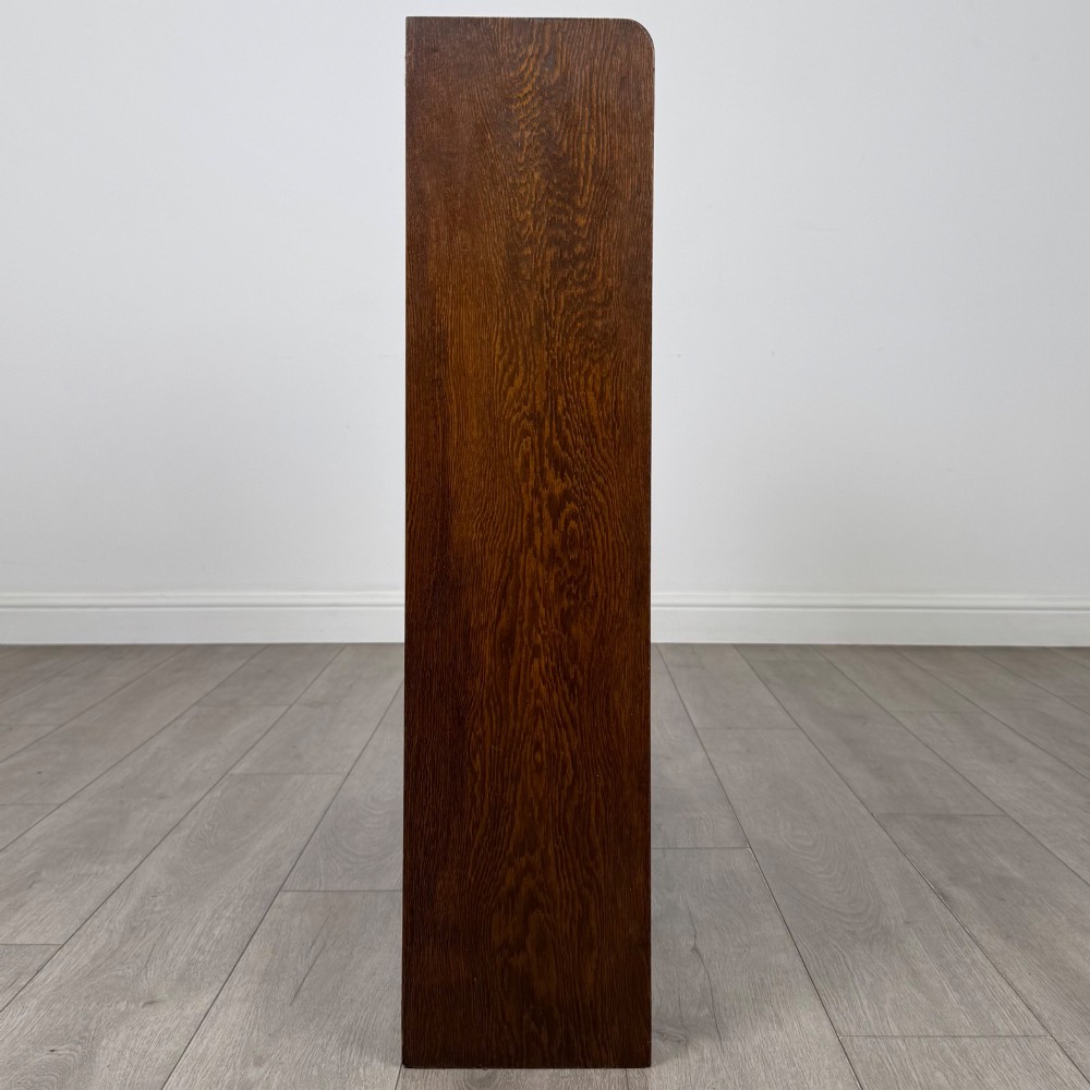 A mid-twentieth-century dark oak display cabinet featuring three interior shelf tiers enclosed by sliding glass doors. View VIII