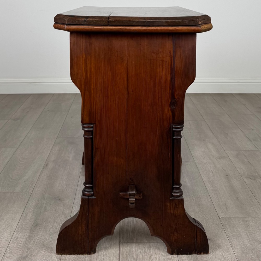 An antique 19th-century pitch pine side table featuring a Gothic Revival trestle base with turned column details and a pegged stretcher. View II