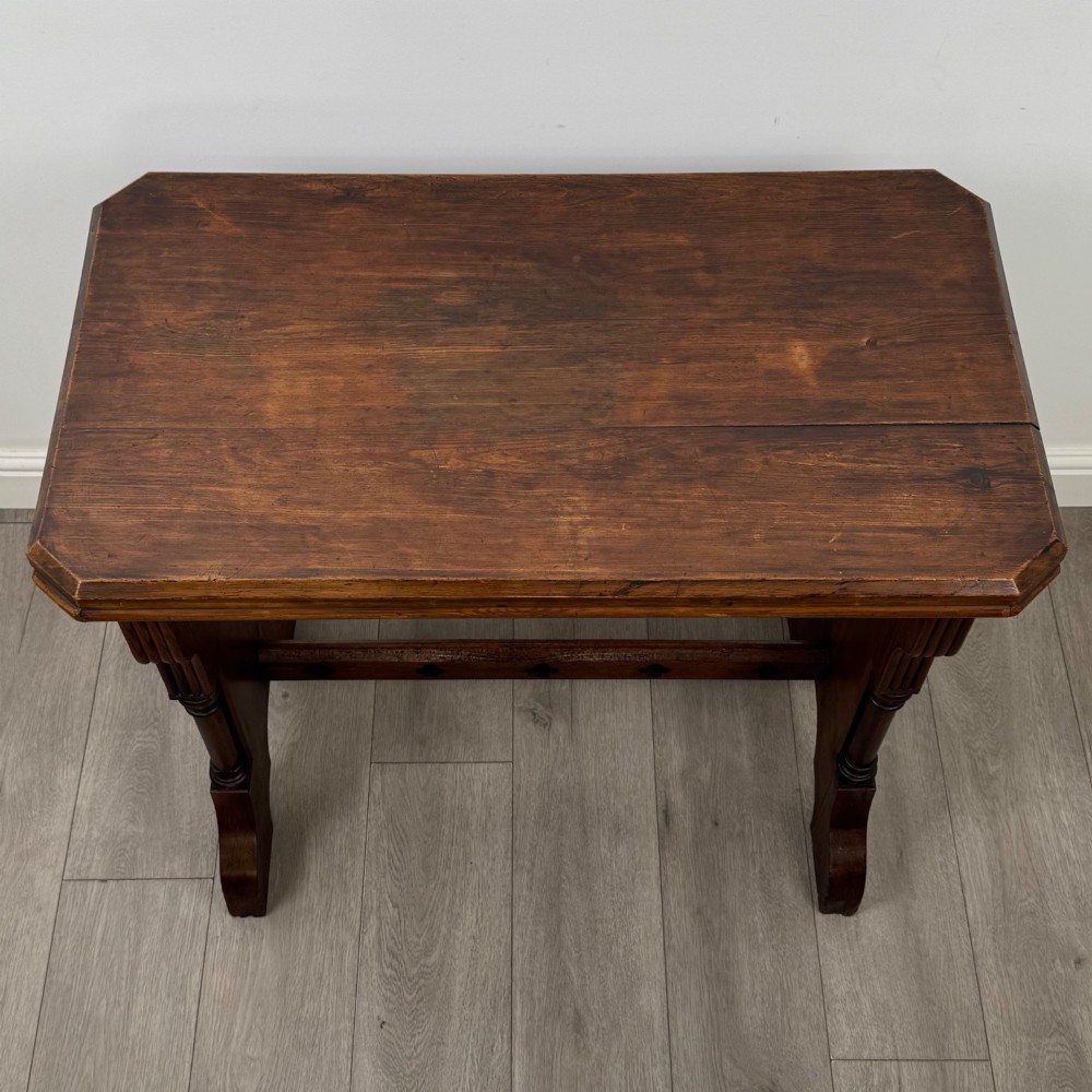 An antique 19th-century pitch pine side table featuring a Gothic Revival trestle base with turned column details and a pegged stretcher. View IV
