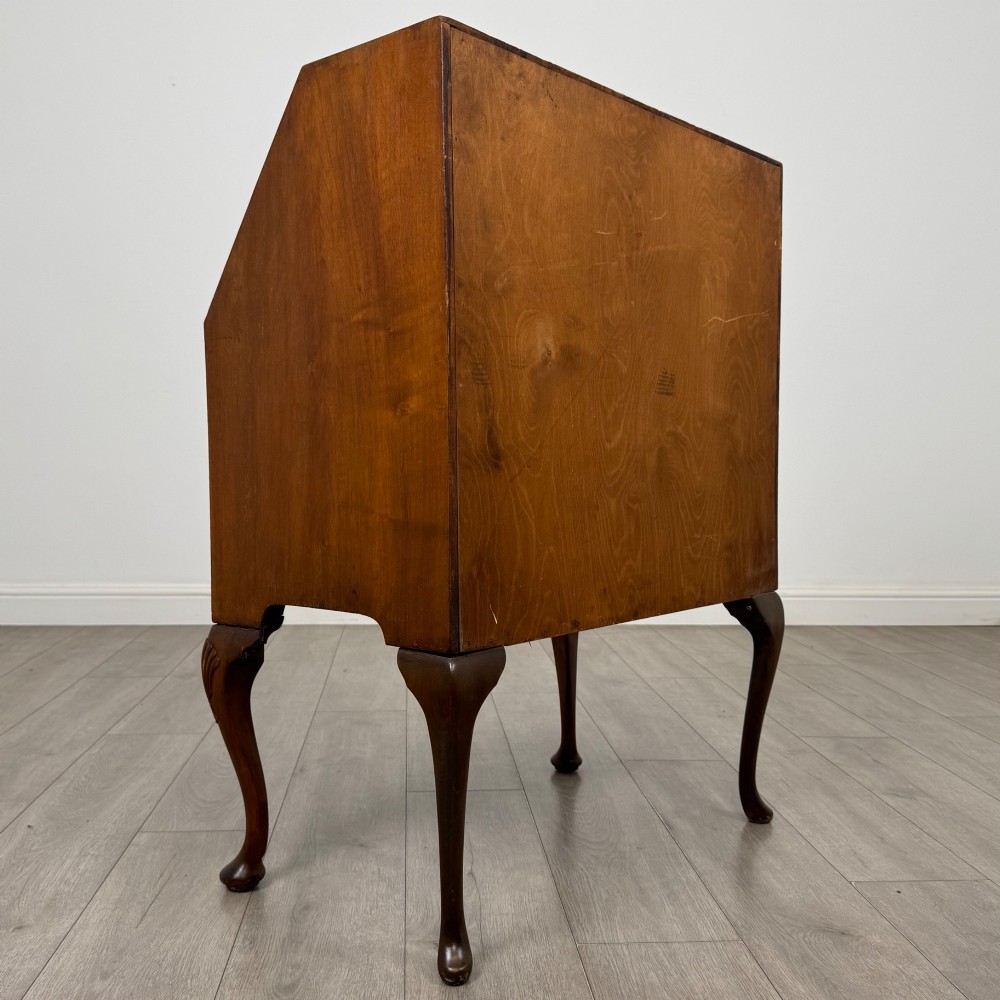 An antique Edwardian burr walnut slant-front bureau featuring two drawers with metal handles, supported by carved cabriole legs. View V