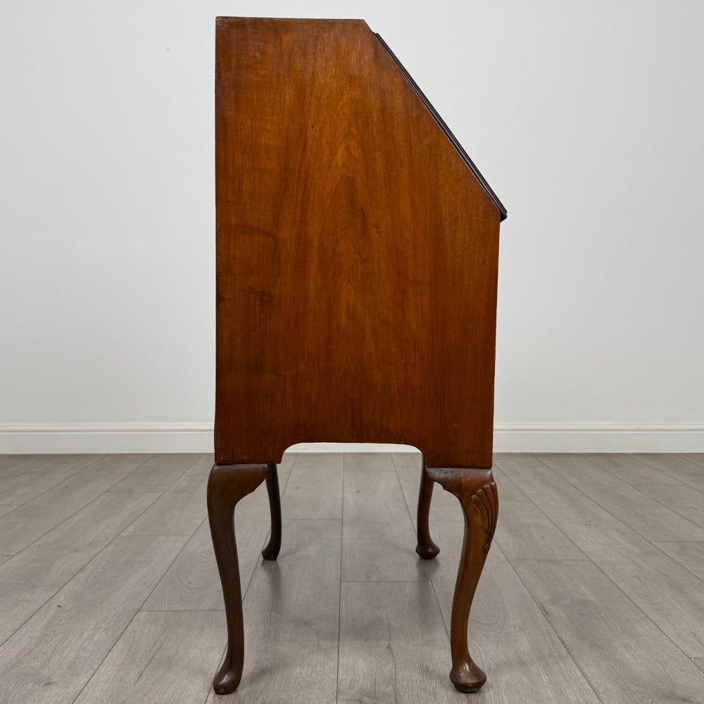 An antique Edwardian burr walnut slant-front bureau featuring two drawers with metal handles, supported by carved cabriole legs. View VIII