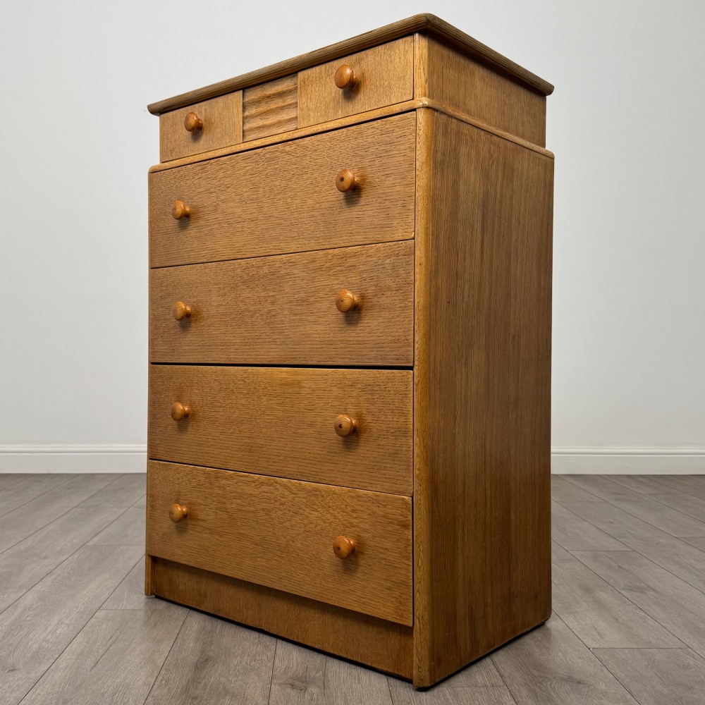 A twentieth-century oak chest featuring four large horizontal drawers below two smaller upper drawers with turned wooden handles and a central carved fluted detail. View II
