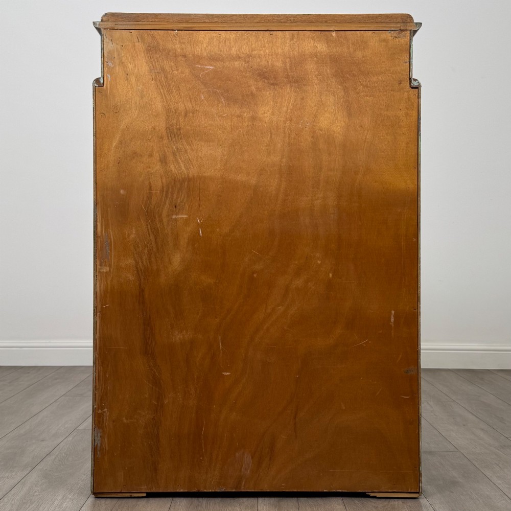 A twentieth-century oak chest featuring four large horizontal drawers below two smaller upper drawers with turned wooden handles and a central carved fluted detail. View V