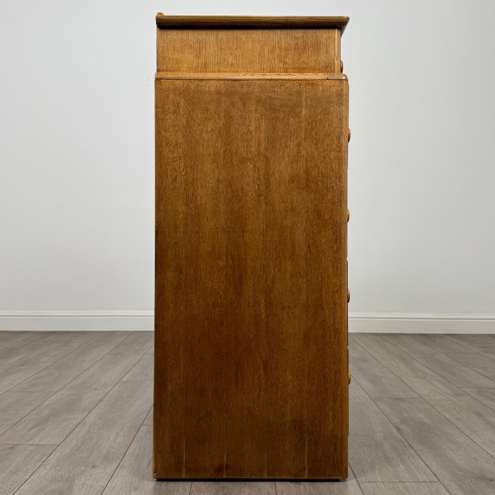 A twentieth-century oak chest featuring four large horizontal drawers below two smaller upper drawers with turned wooden handles and a central carved fluted detail. View VII