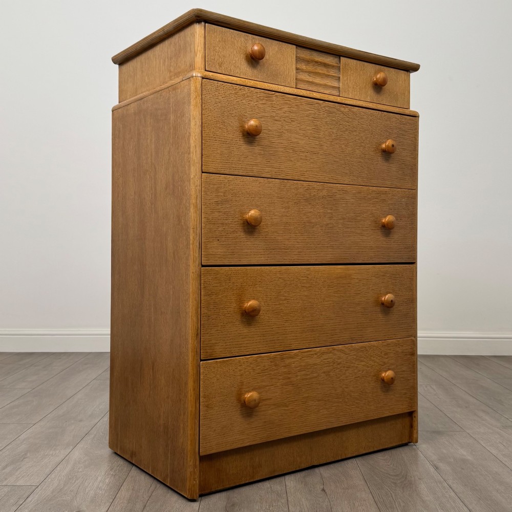 A twentieth-century oak chest featuring four large horizontal drawers below two smaller upper drawers with turned wooden handles and a central carved fluted detail. View VIII