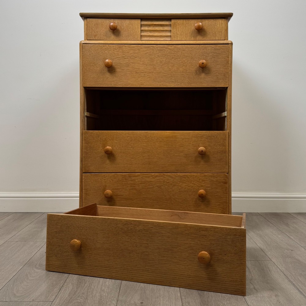 A twentieth-century oak chest featuring four large horizontal drawers below two smaller upper drawers with turned wooden handles and a central carved fluted detail. View X
