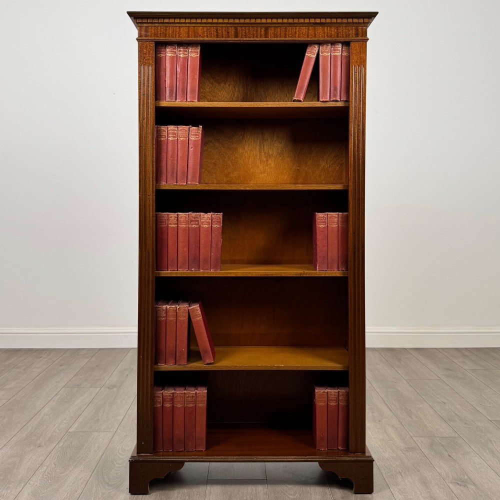 A tall early 20th-century mahogany open bookcase featuring fluted side pilasters, a crossbanded cornice, five shelves, and bracket feet.