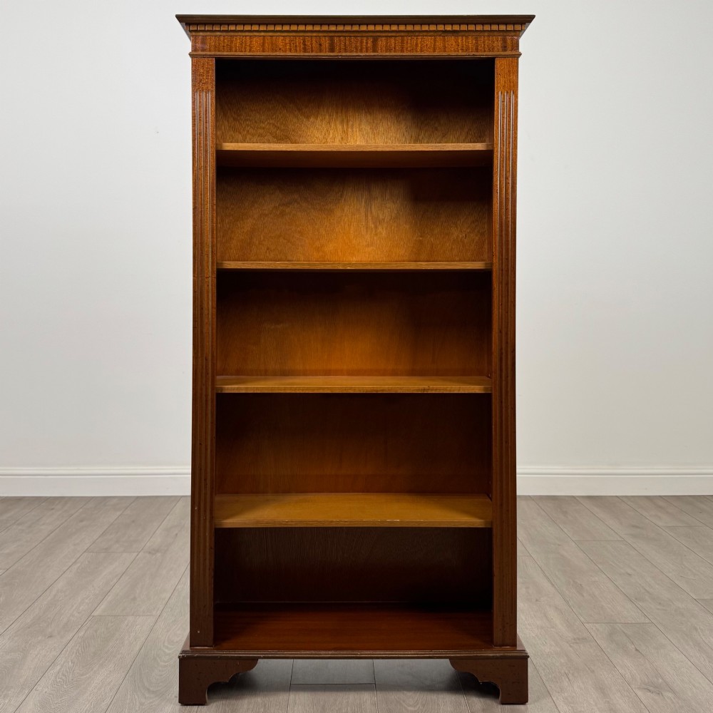 A tall early 20th-century mahogany open bookcase featuring fluted side pilasters, a crossbanded cornice, five shelves, and bracket feet. View II