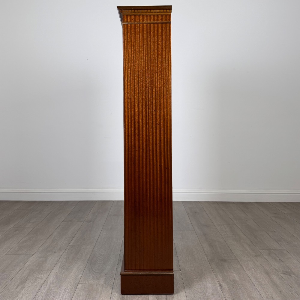 A tall early 20th-century mahogany open bookcase featuring fluted side pilasters, a crossbanded cornice, five shelves, and bracket feet. View IV