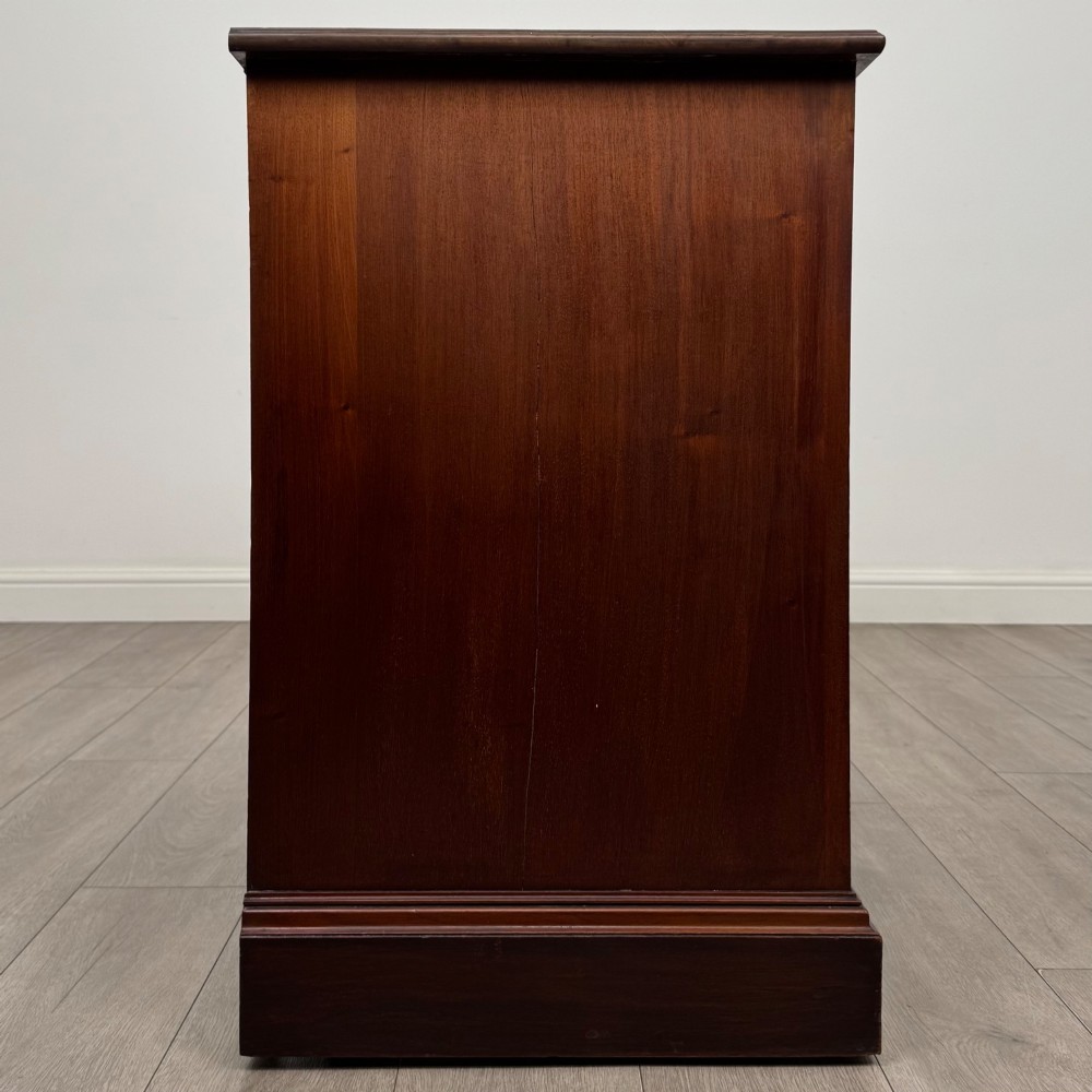 An antique mahogany chest of drawers featuring two short top drawers over two long lower drawers with decorative metal handles on a plinth base. View VII
