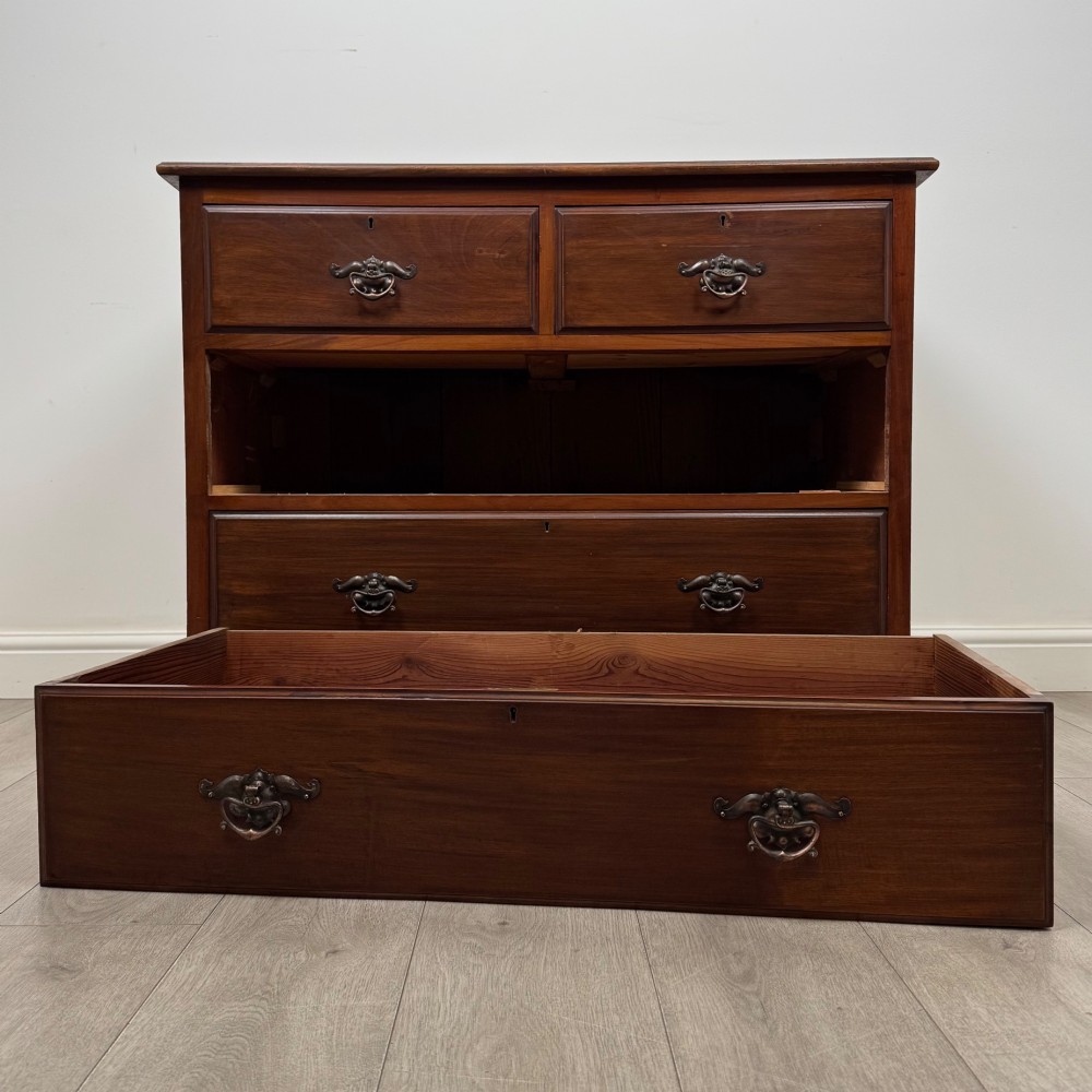 An antique mahogany chest of drawers featuring two short top drawers over two long lower drawers with decorative metal handles on a plinth base. View X