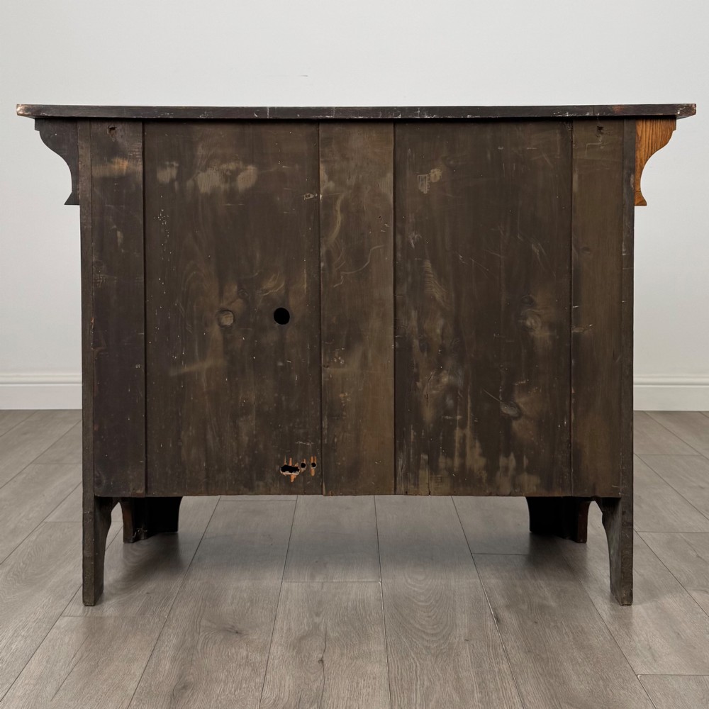 An Arts and Crafts golden oak sideboard featuring two top drawers, two lower cupboard doors, and stylized copper strap hinges. View VI