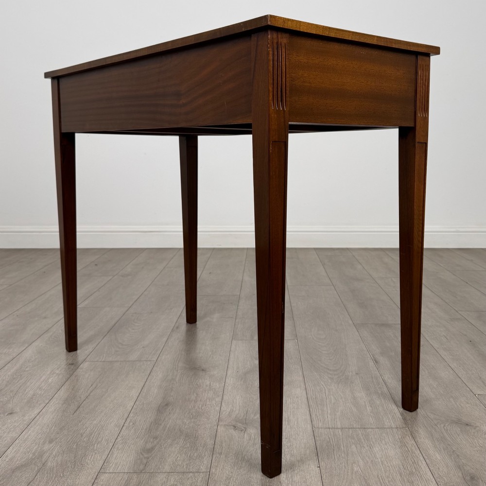 A 20th-century burr walnut side table featuring a serpentine front, three drawer fronts with brass handles, and square tapered legs. View VI