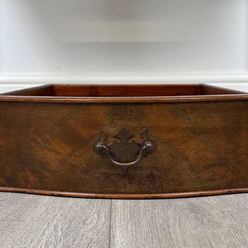 A 20th-century burr walnut side table featuring a serpentine front, three drawer fronts with brass handles, and square tapered legs. View XI