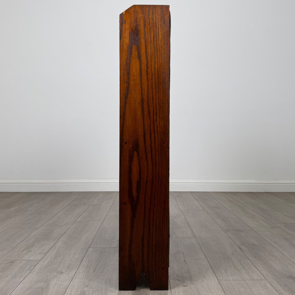 An Edwardian dark oak open bookcase featuring four fixed shelves and shaped side panels. View IV