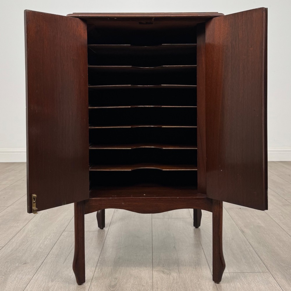 An antique Edwardian mahogany cabinet with double panelled doors, brass knobs, and elevated curved legs. View II