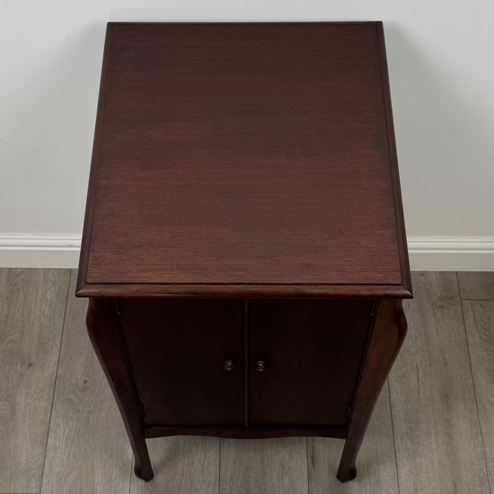 An antique Edwardian mahogany cabinet with double panelled doors, brass knobs, and elevated curved legs. View X
