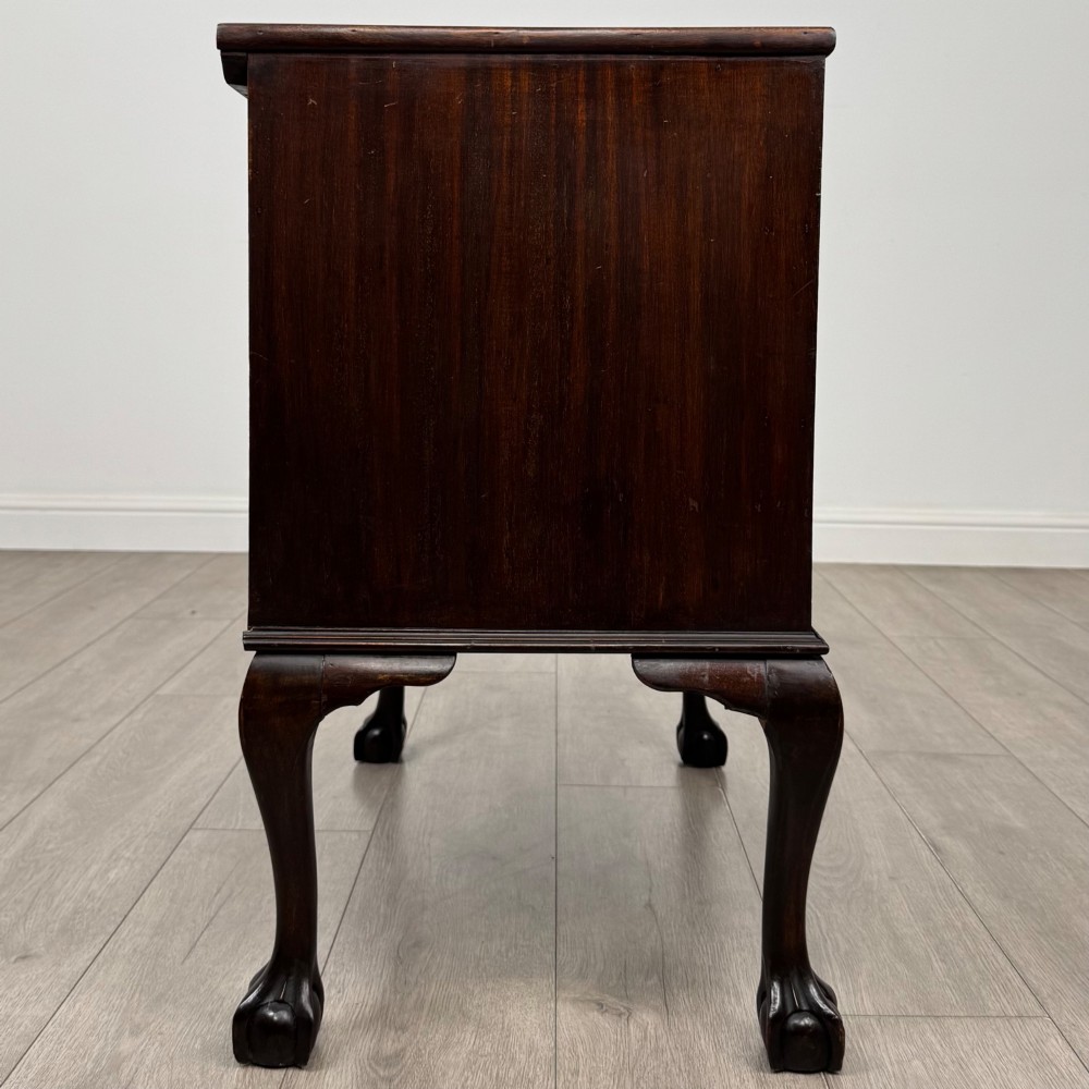 A dark mahogany chest of drawers featuring three long drawers with brass handles, raised on carved cabriole legs ending in ball and claw feet. View VII