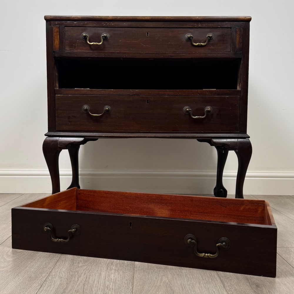 A dark mahogany chest of drawers featuring three long drawers with brass handles, raised on carved cabriole legs ending in ball and claw feet. View X