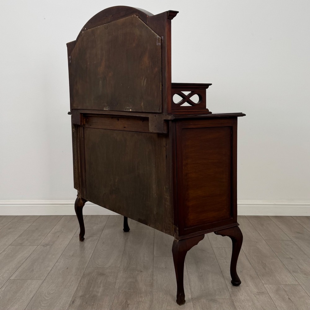 An antique Edwardian mahogany sideboard featuring a top section with a central oval mirror, two drawers, and a two-door cabinet below raised on cabriole legs. View VII