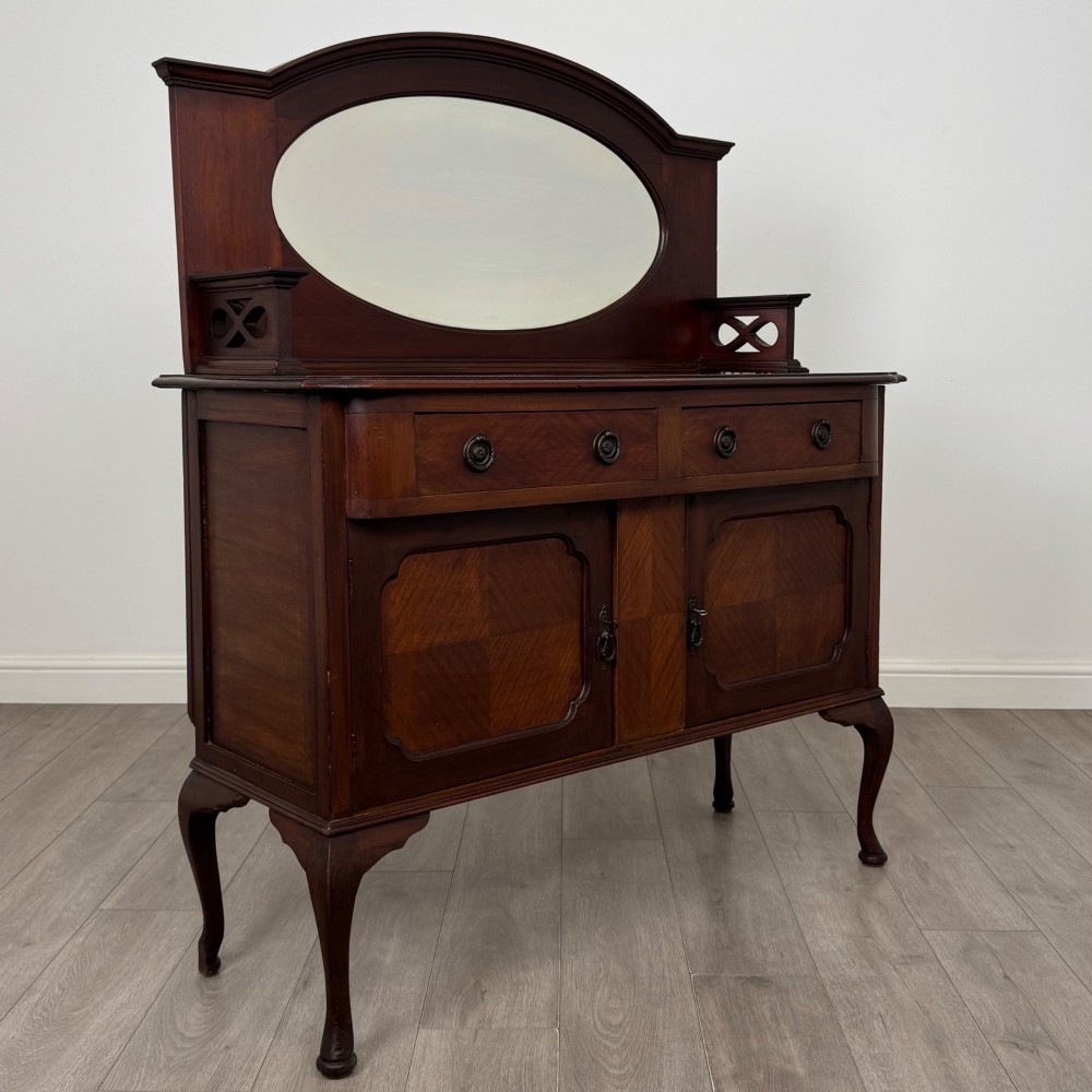 An antique Edwardian mahogany sideboard featuring a top section with a central oval mirror, two drawers, and a two-door cabinet below raised on cabriole legs. View IX