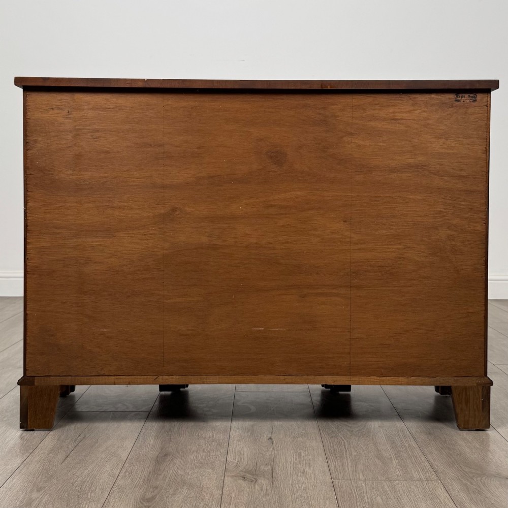 An antique 20th-century small breakfront sideboard with figured burr walnut veneers, brass drop handles, four central drawers, and side cupboard doors. View VI